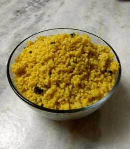 cooked millet in a glass bowl on marble counter