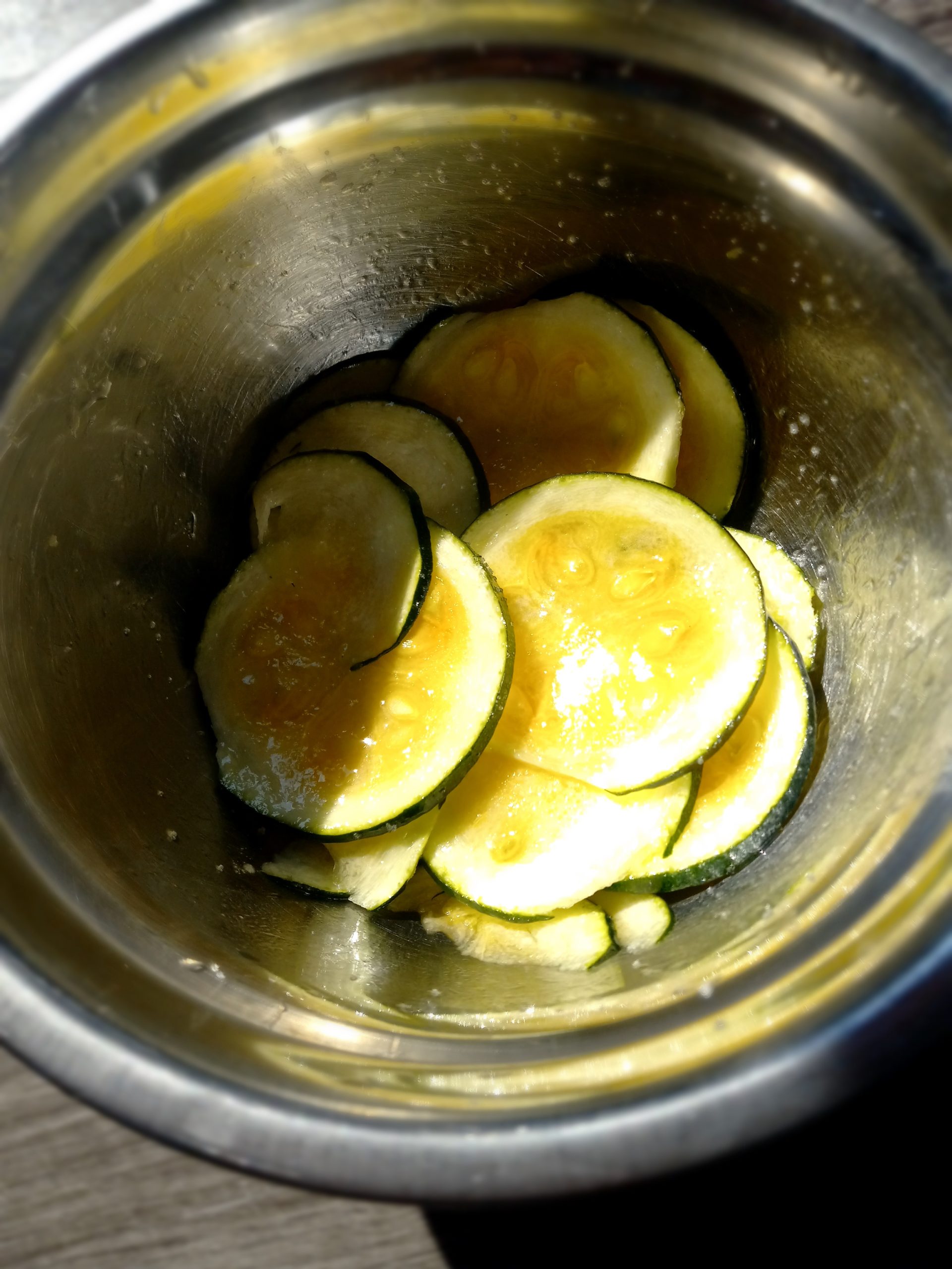 Picture of marinated zucchini in a small metal bowl.