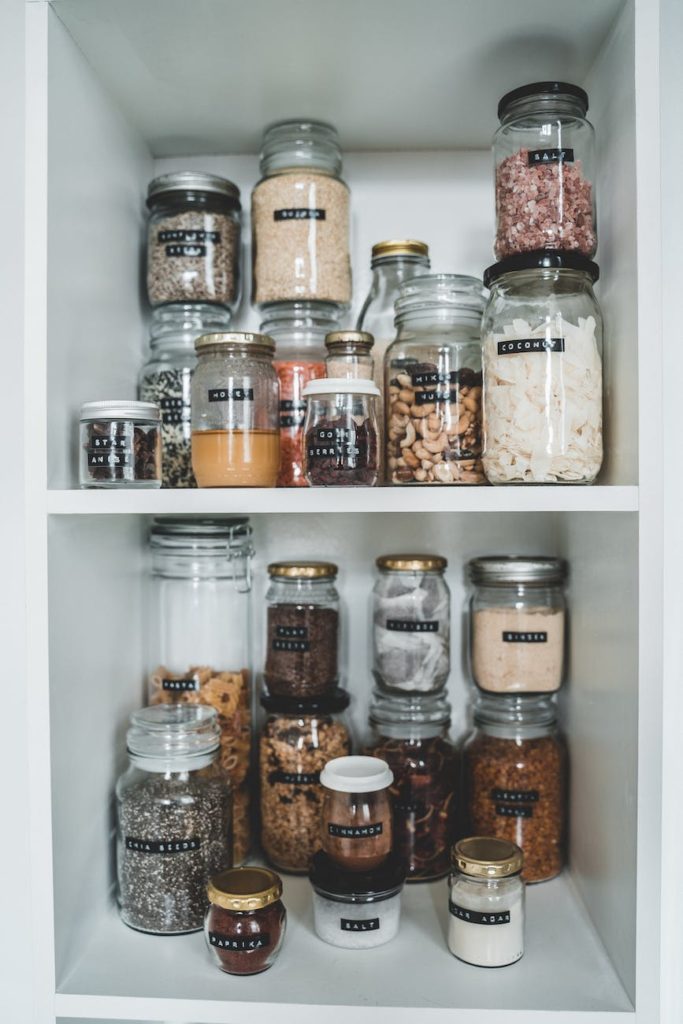 clear glass jars on white wooden shelf