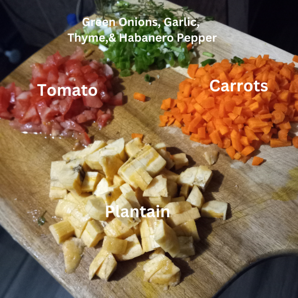 chopped carrots, plantain, tomato, and seasonings on a wooden cutting board.