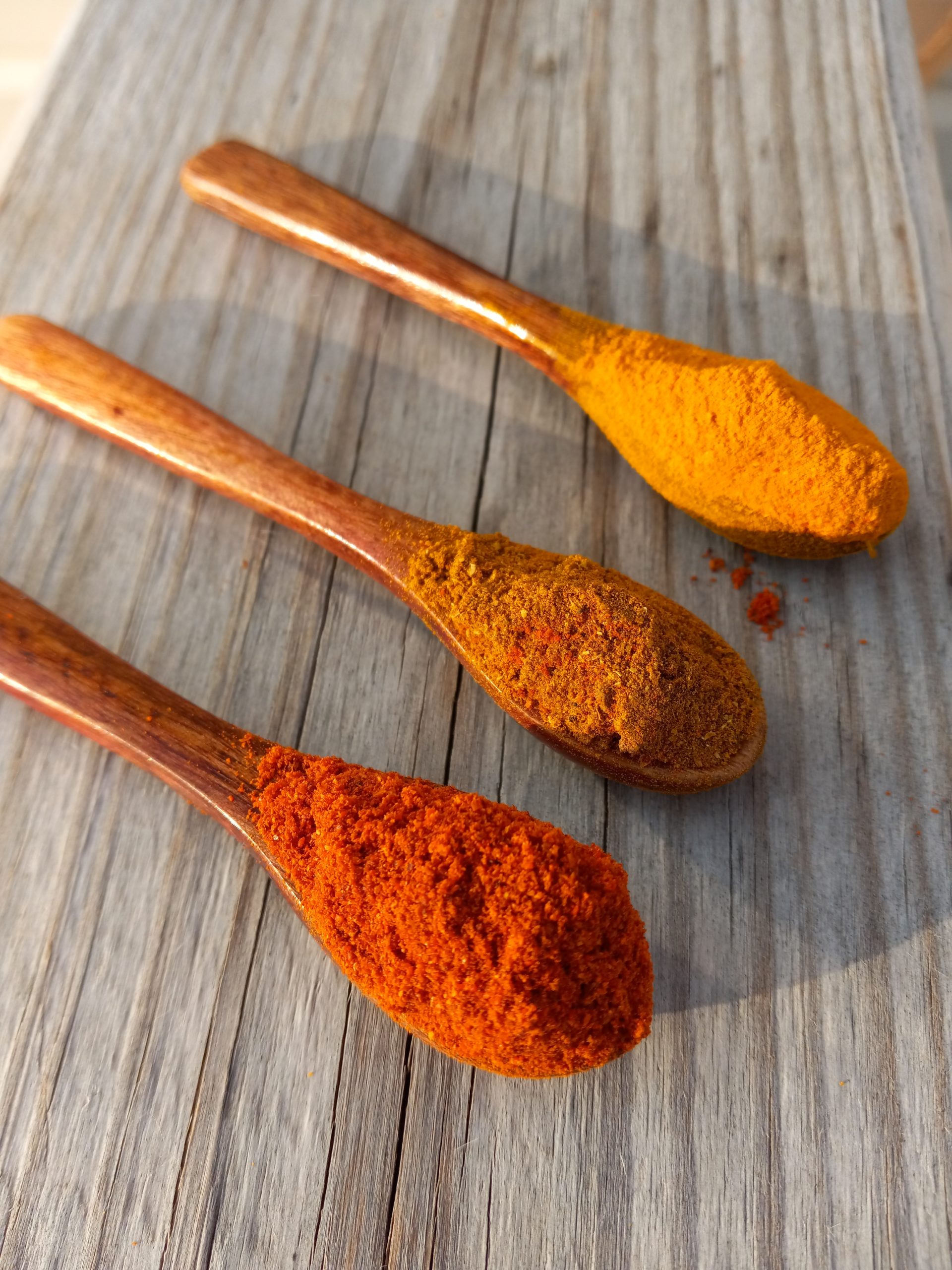 3 wooden spices filled with spices