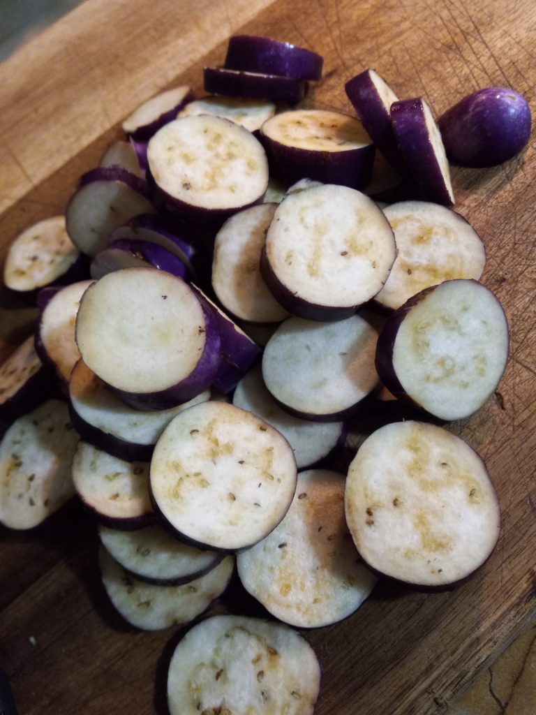 chopped eggplant on a wooden cutting board.