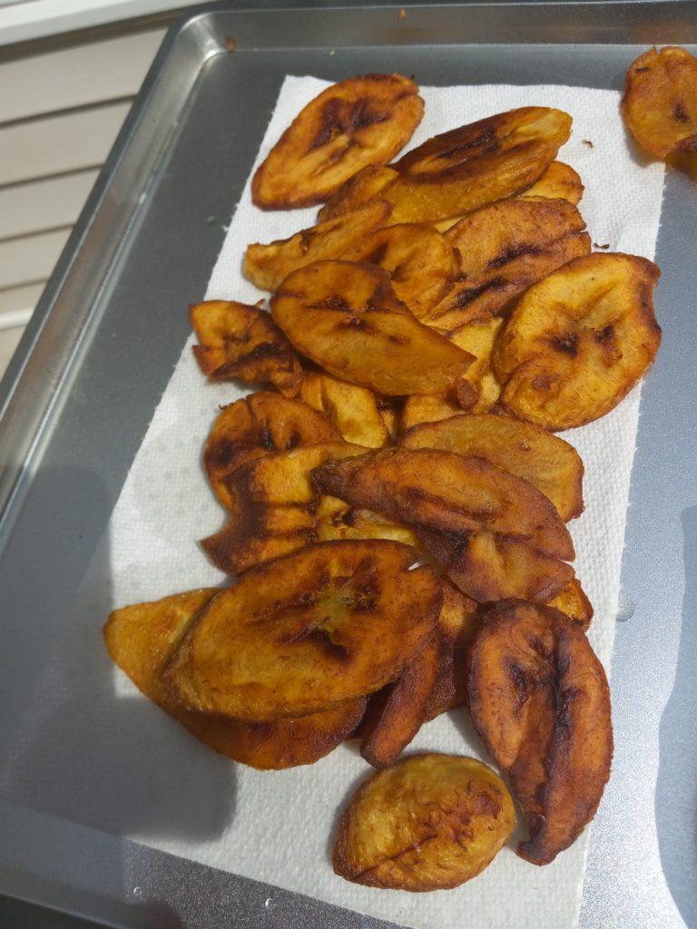 FRIED PLANTAINS ON A SMALL BAKING TRAY LINED WITH A PAPER TOWEL