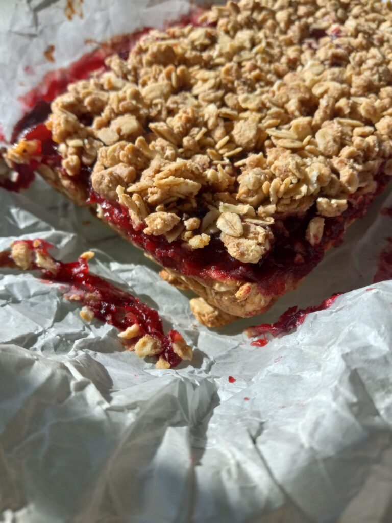 a pan of cranberry oat crumble bar on parchment paper