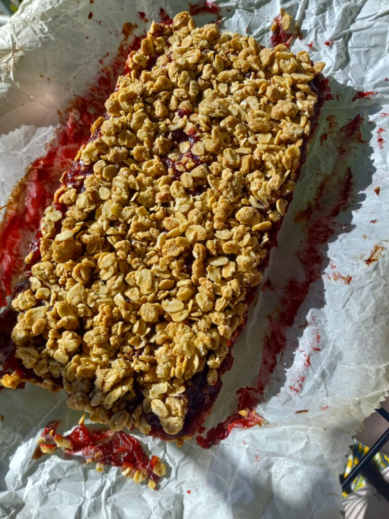 a pan of cranberry oat crumble bar on parchment paper