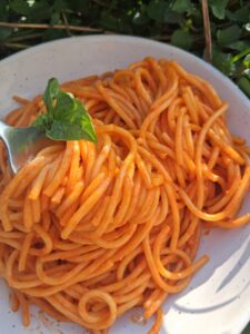 plate of roasted red pepper pasta with a fork twirling a few strands of spagetti.